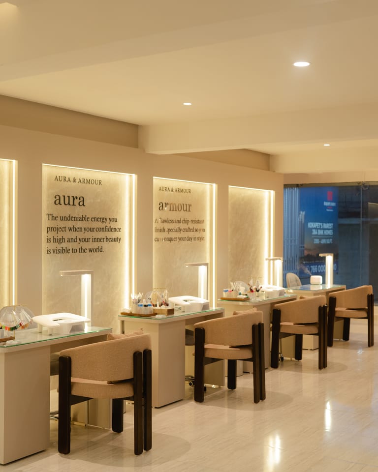 Empty manicure desks beneath backlit stone wall panels